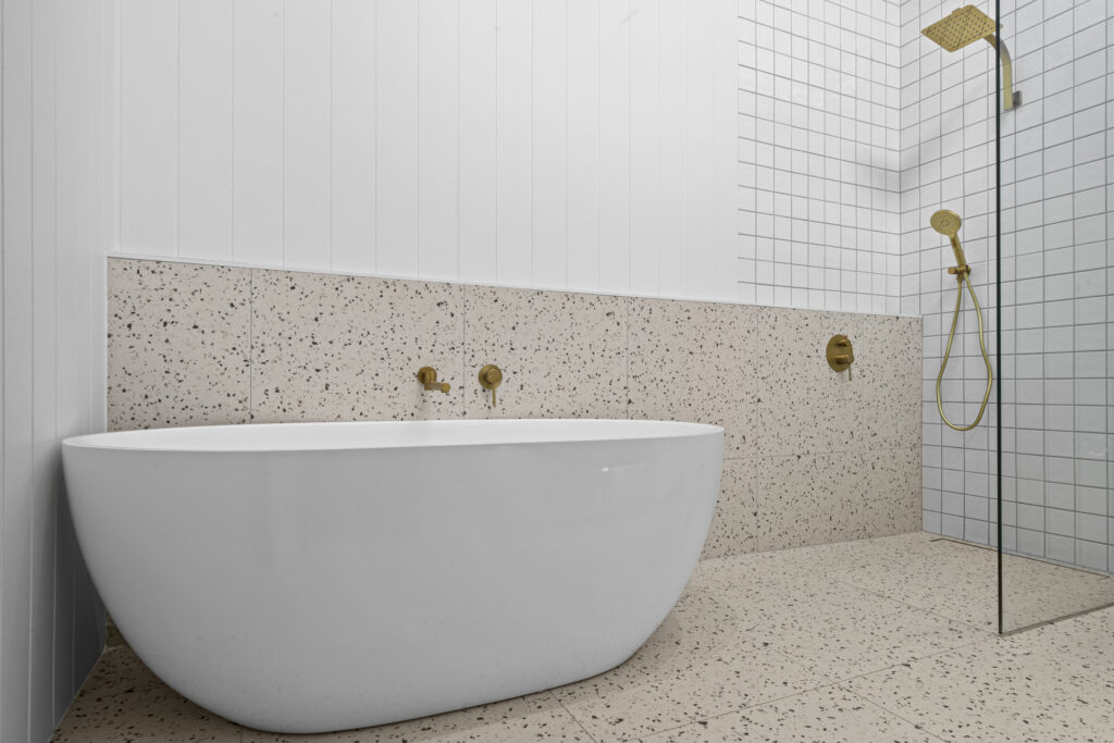 Renovated bathroom with freestanding bath, terrazzo tiles and brass tapware by Daylo Build