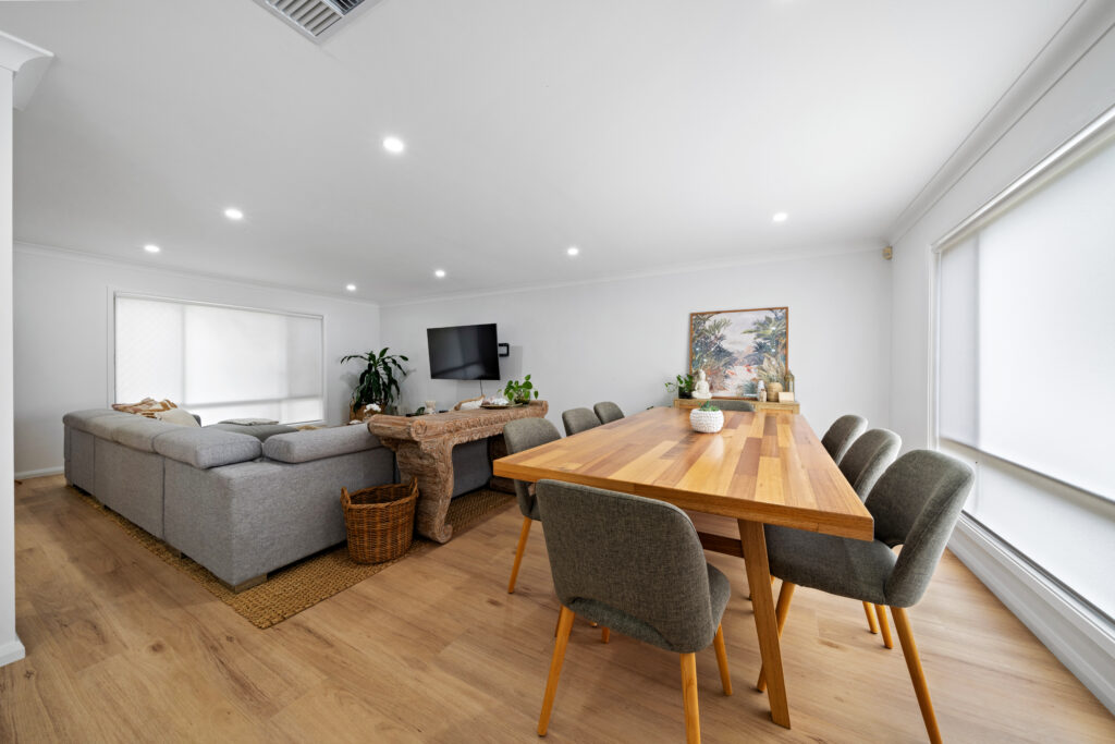 Renovated open-plan living and dining area with timber dining table