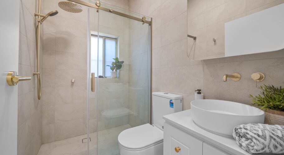 Bathroom with brass shower and glass screen, West Ryde Renovated bathroom with brass shower fittings, glass screen and vanity in West Ryde by Daylo Build