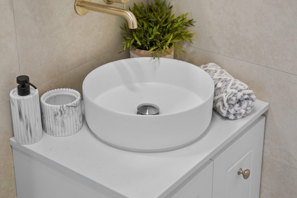 Round vessel basin, white vanity and brushed brass wall tap in a West Ryde bathroom renovation