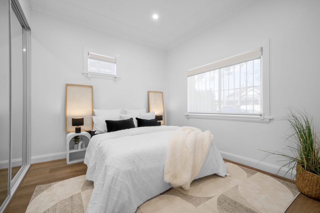 Renovated bedroom with mirrored built-in wardrobe and timber flooring in West Ryde