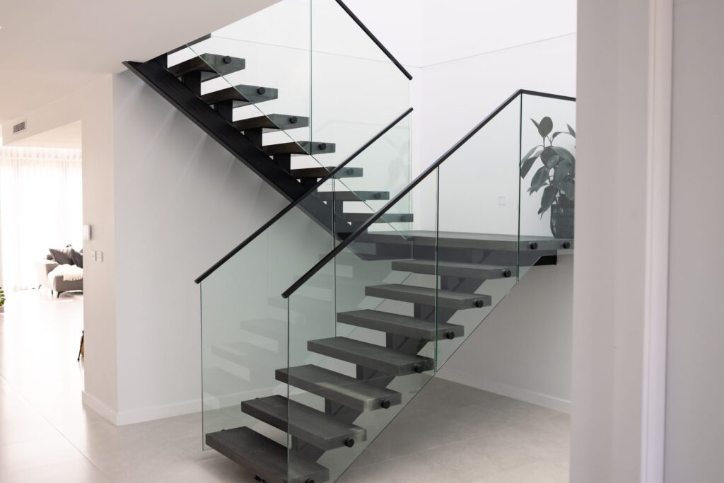 Floating staircase with black treads and glass balustrade in a Box Hill home