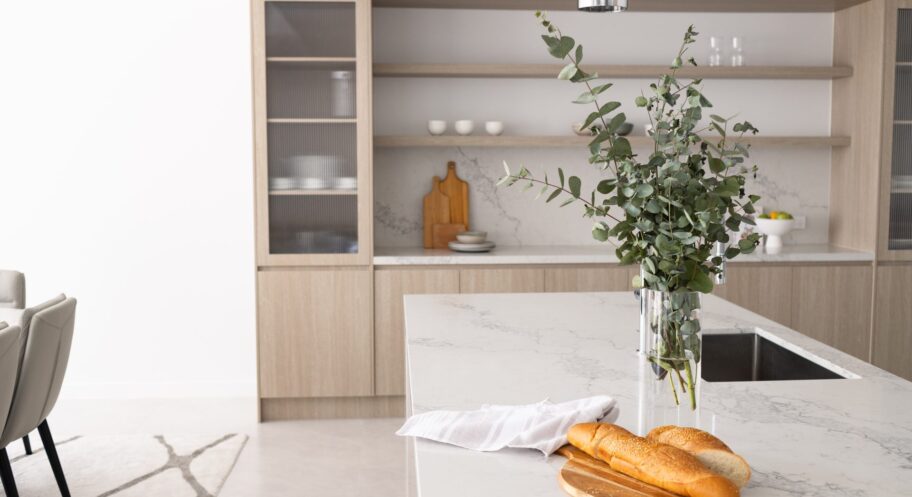 Kitchen with fluted timber island and stone benchtop, Box Hill Custom kitchen with fluted timber island bench, stone benchtop and joinery wall in a Box Hill home renovation by Daylo Build