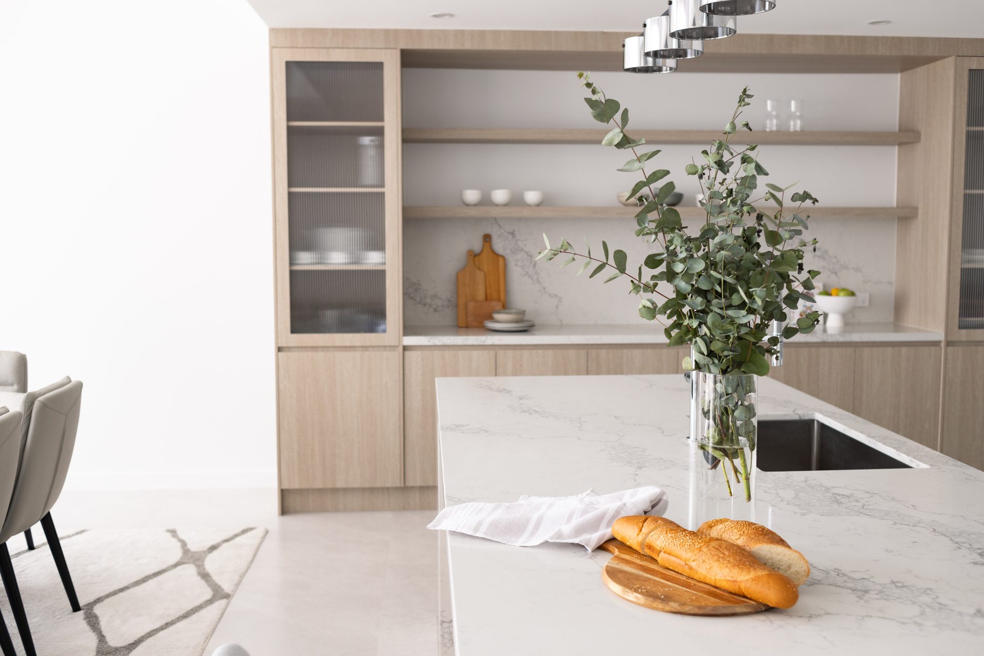Custom kitchen with fluted timber island bench, stone benchtop and joinery wall in a Box Hill home renovation by Daylo Build
