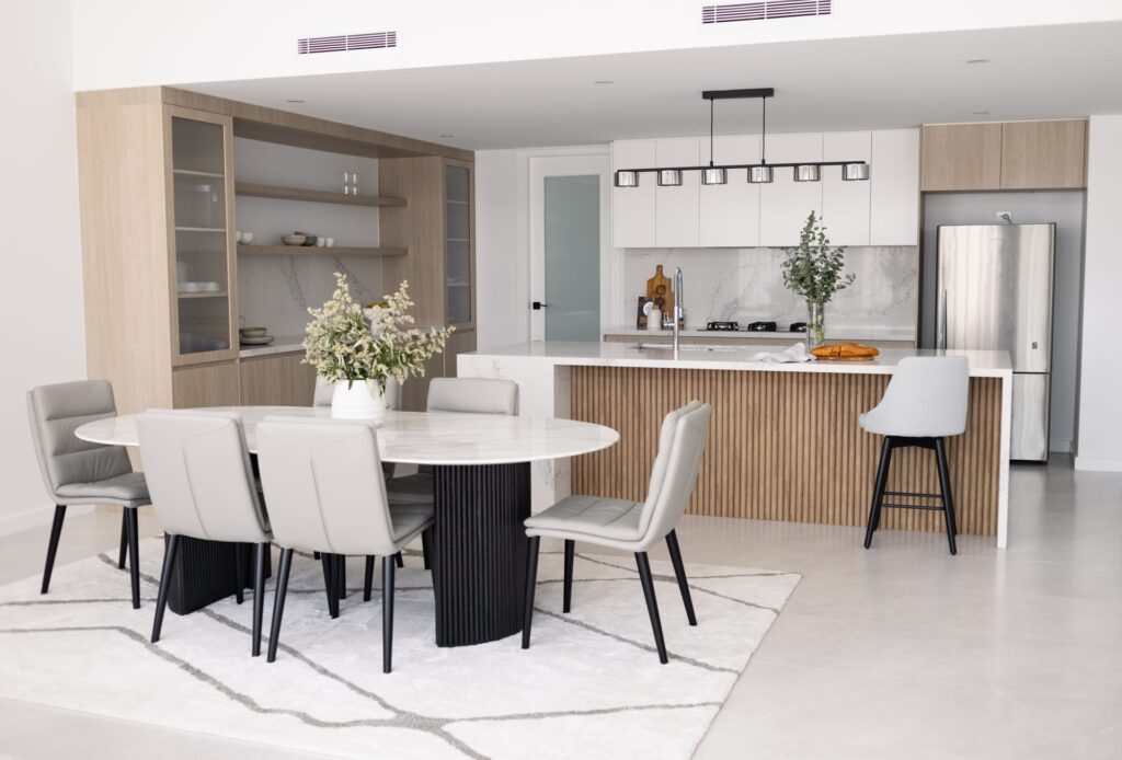 Open-plan kitchen, dining and living area with custom joinery and island bench in a Box Hill home by Daylo Build