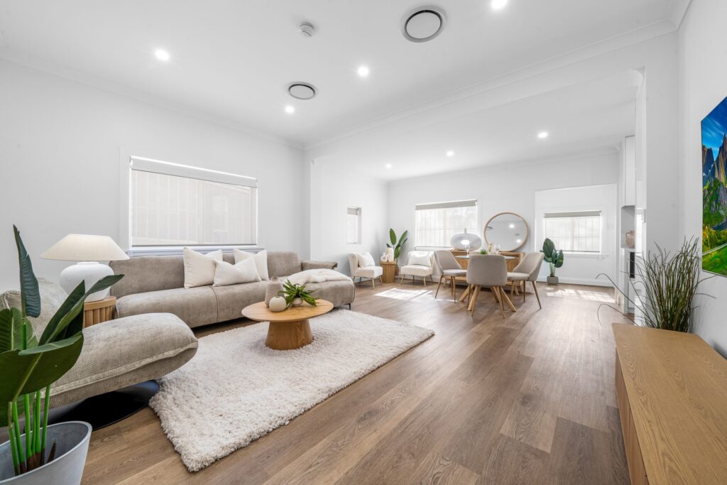 Renovated open-plan living and dining room with timber flooring in West Ryde by Daylo Build